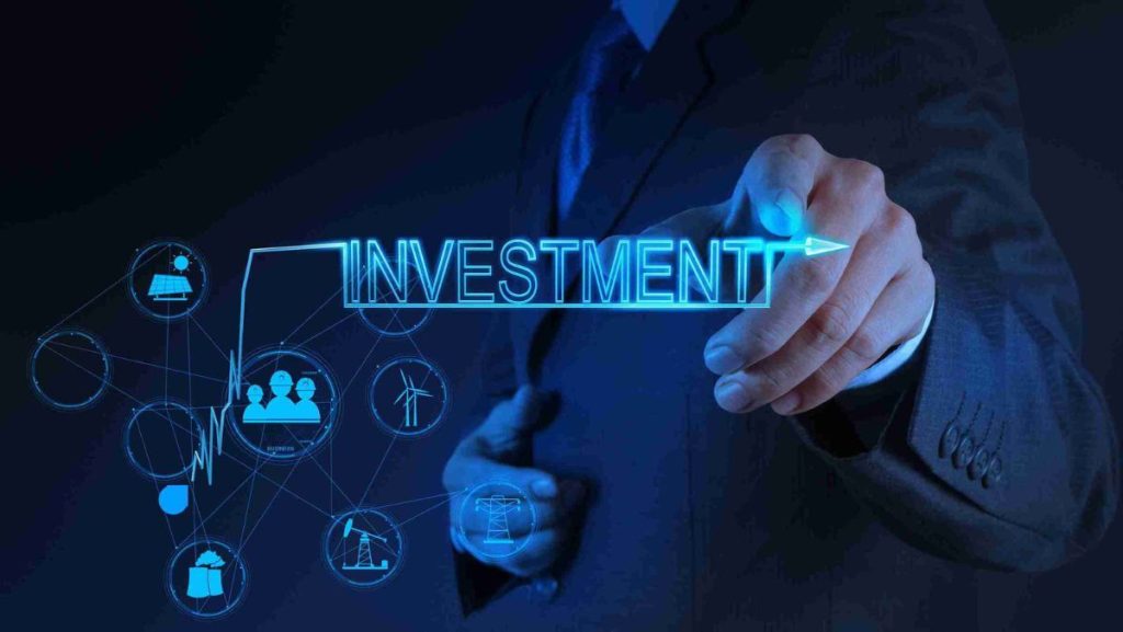 Businessman touching a glowing “Investment” word on a digital interface with finance icons